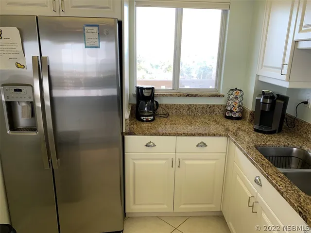 a kitchen with sink refrigerator and window