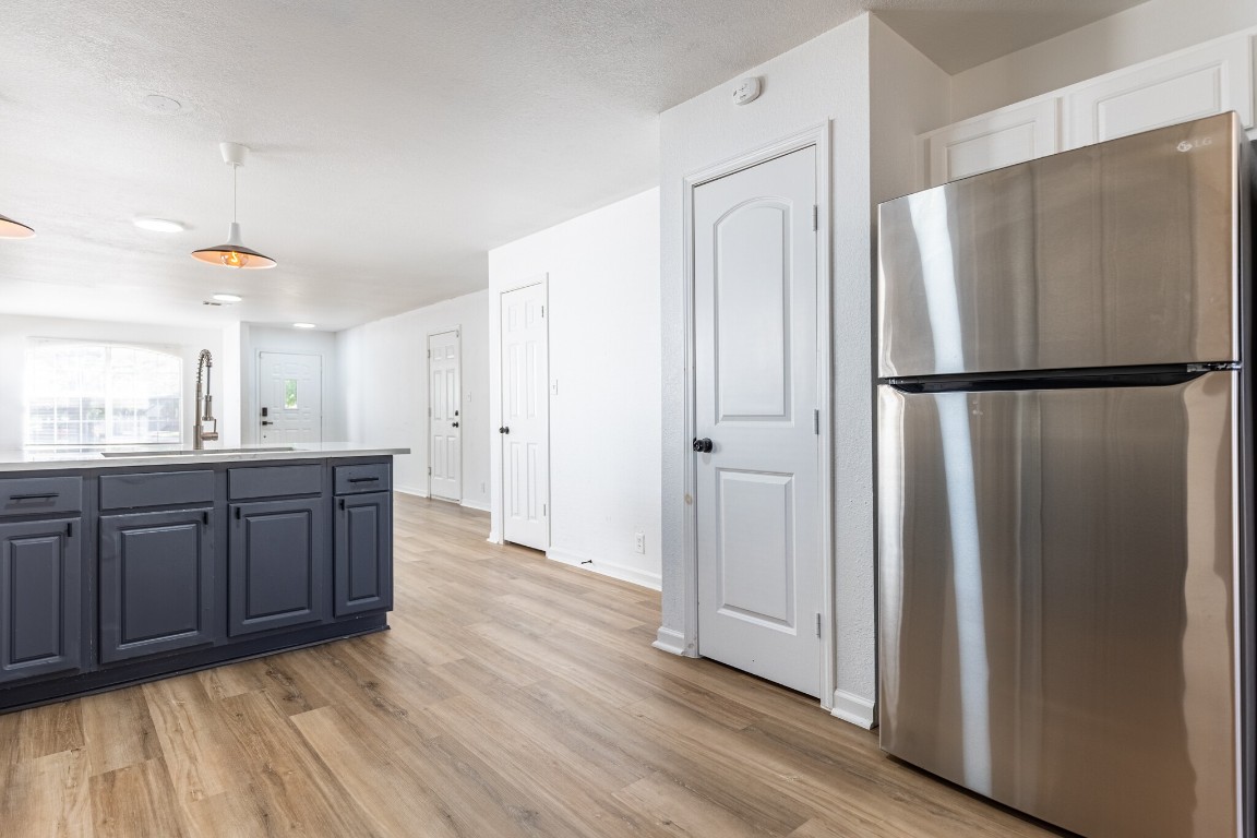 2012 Balsam Way Round Rock, TX 78665 - Photo 12 of 30 Kitchen with freestanding refrigerator, pendant lighting, light countertops, and light wood-type flooring