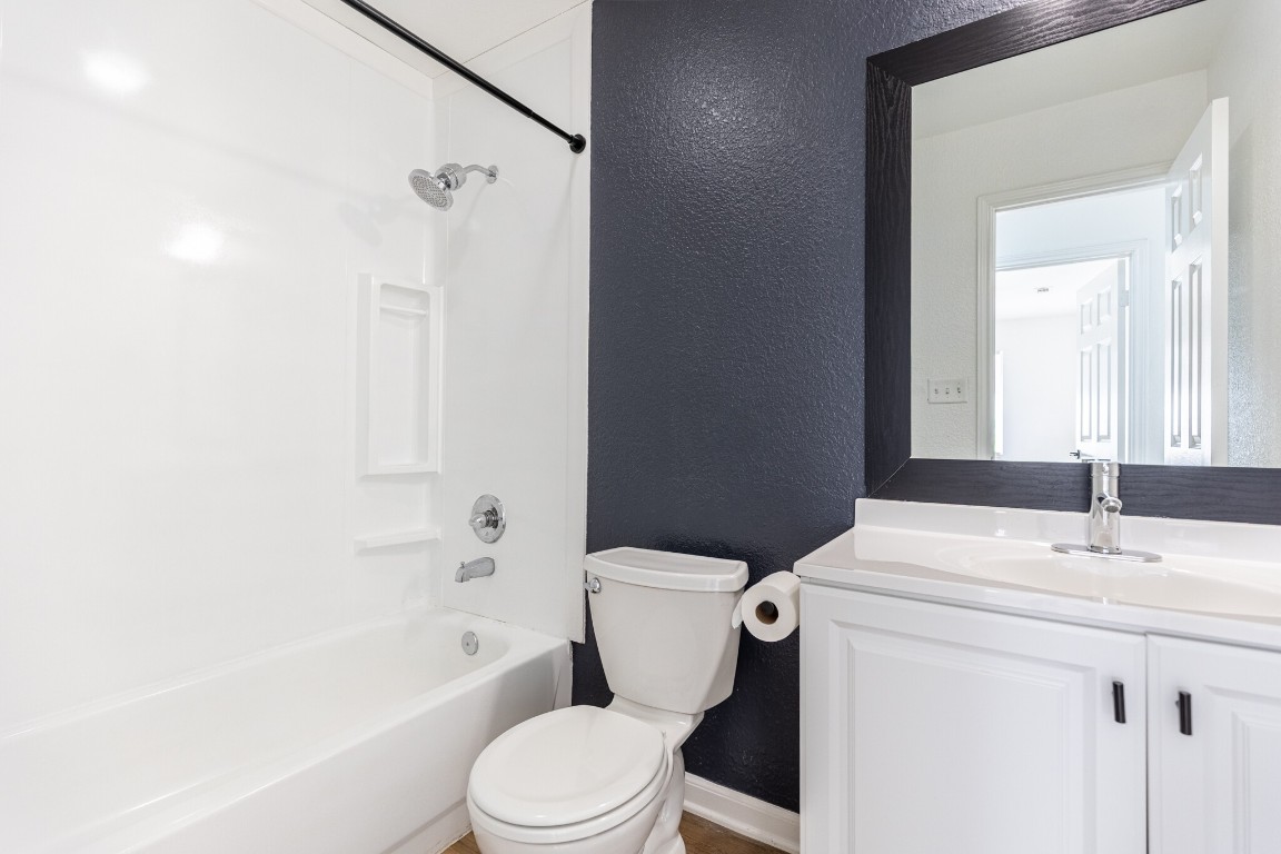 2012 Balsam Way Round Rock, TX 78665 - Photo 17 of 30 Bathroom with a textured wall, washtub / shower combination, and vanity