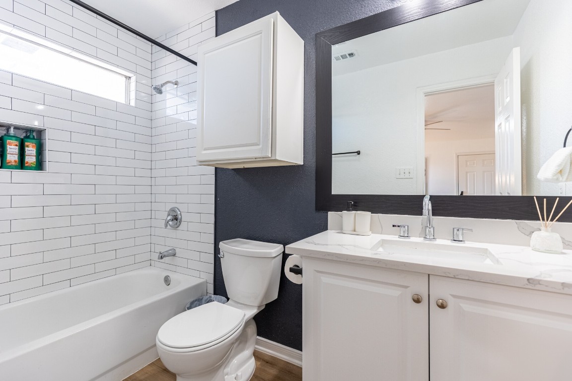 2012 Balsam Way Round Rock, TX 78665 - Photo 24 of 30 Bathroom featuring tub / shower combination, vanity, and a textured wall