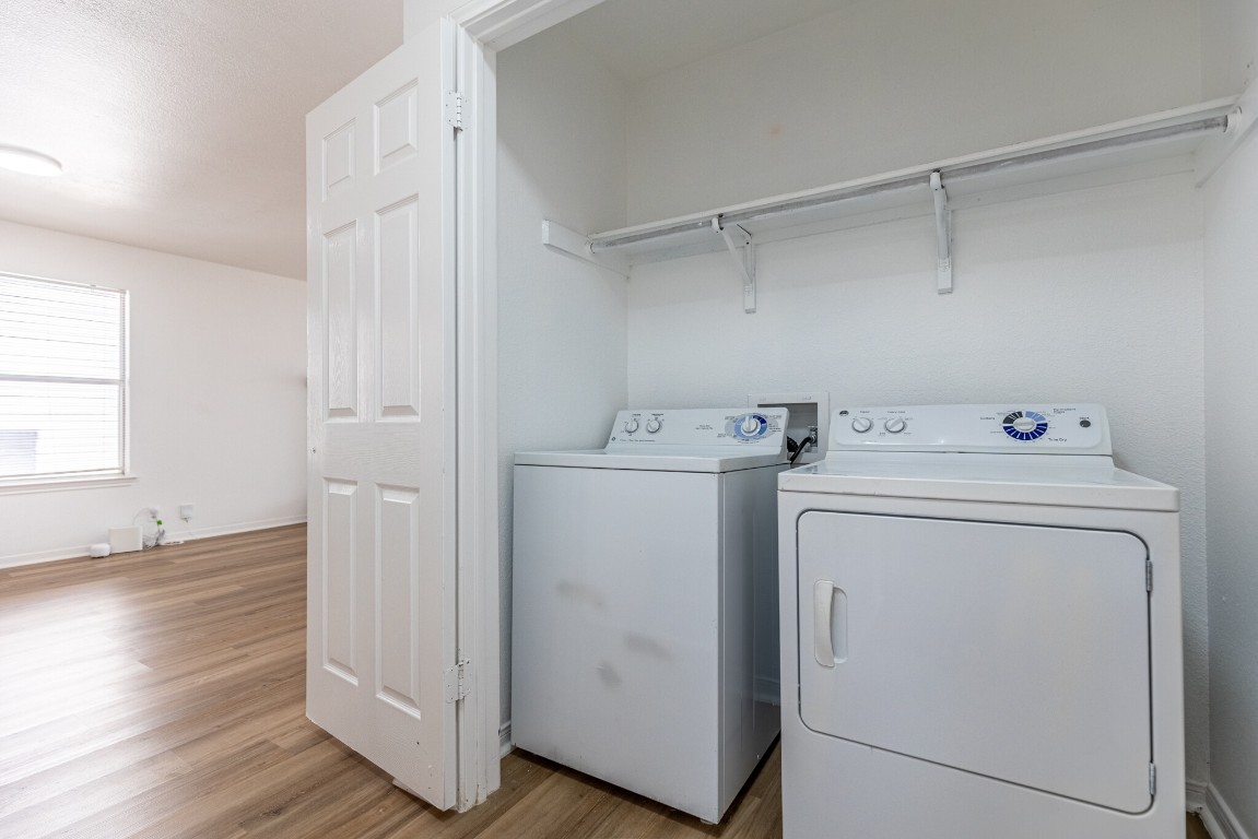 2012 Balsam Way Round Rock, TX 78665 - Photo 25 of 30 Washroom with light wood-style floors, washer and clothes dryer, and a textured ceiling