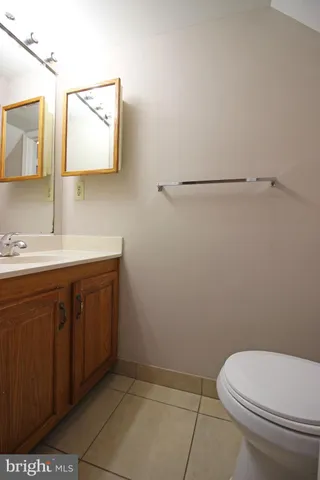 a bathroom with a toilet sink vanity and mirror