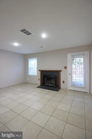 an empty room with windows and fireplace