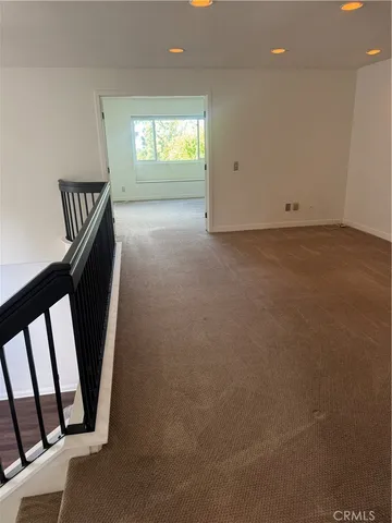 an empty room with wooden floor and entryway