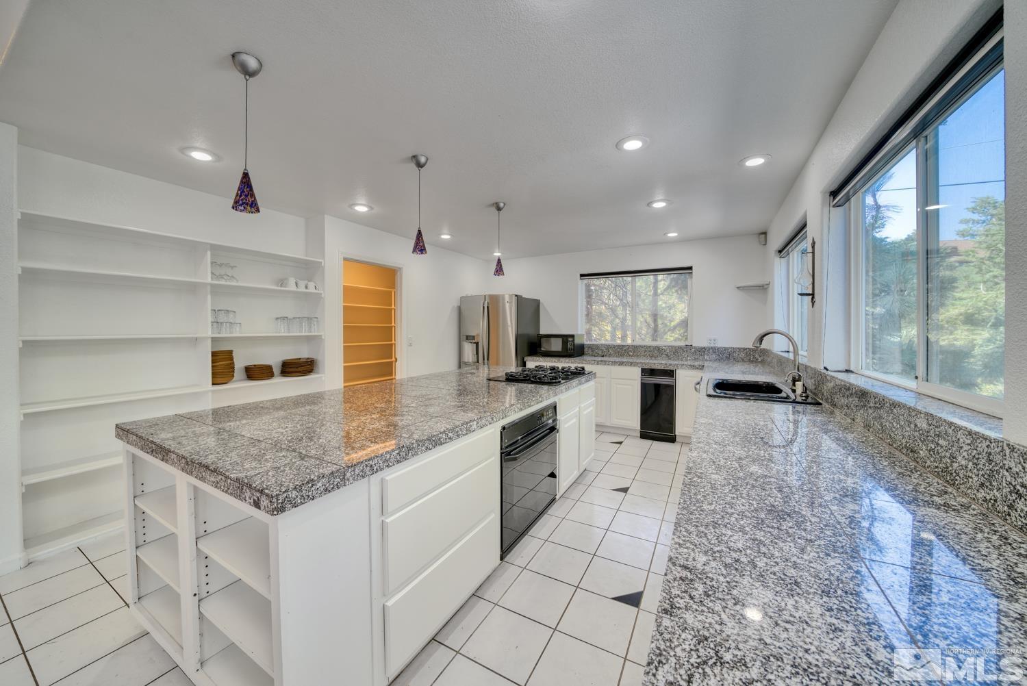 50 Sunridge Drive Reno, NV 89511 - Photo 7 of 30 a large kitchen with kitchen island a large counter top appliances and cabinets