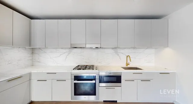 a kitchen with cabinets appliances and a sink