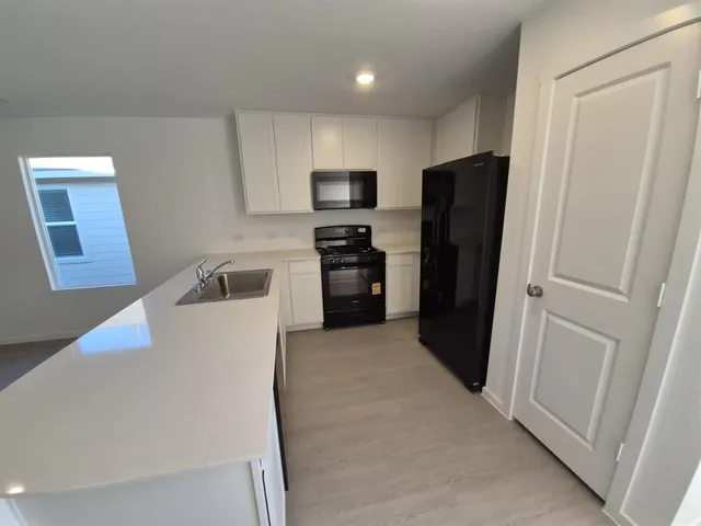a kitchen with a refrigerator and a stove top oven