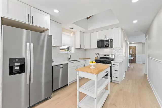 a kitchen with stainless steel appliances a refrigerator stove microwave and sink