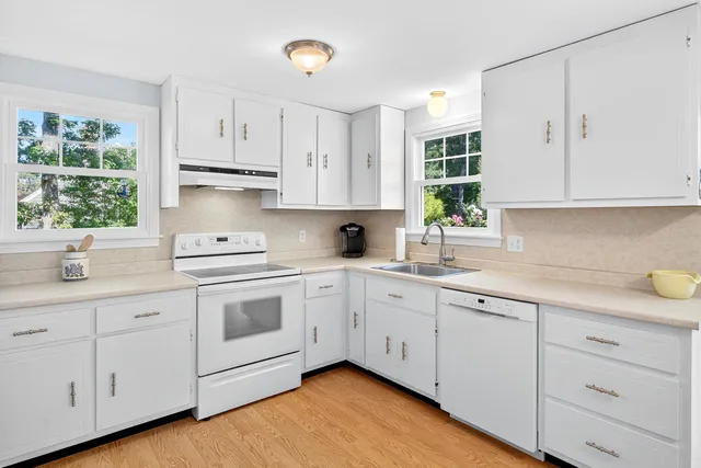 a kitchen with cabinets appliances a sink and a window