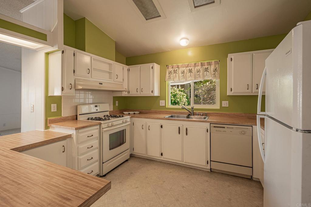 4650 Dulin Road, Unit 175 Fallbrook, CA 92003 - Photo 6 of 53 a kitchen with stainless steel appliances granite countertop a refrigerator sink and cabinets