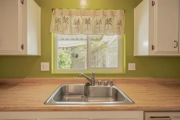 a kitchen with granite countertop a sink a stove and cabinets