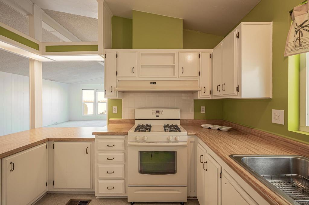 4650 Dulin Road, Unit 175 Fallbrook, CA 92003 - Photo 8 of 53 a kitchen with granite countertop a sink a stove and cabinets