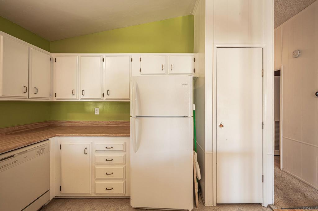 4650 Dulin Road, Unit 175 Fallbrook, CA 92003 - Photo 10 of 53 a close view of a refrigerator in kitchen and white cabinets