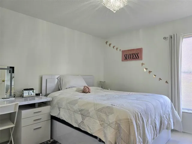 a bedroom with a bed and a chandelier