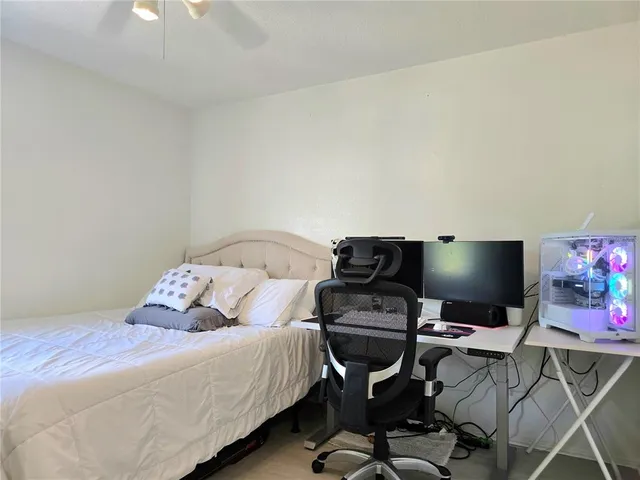 a bedroom with a bed and a computer on a desk