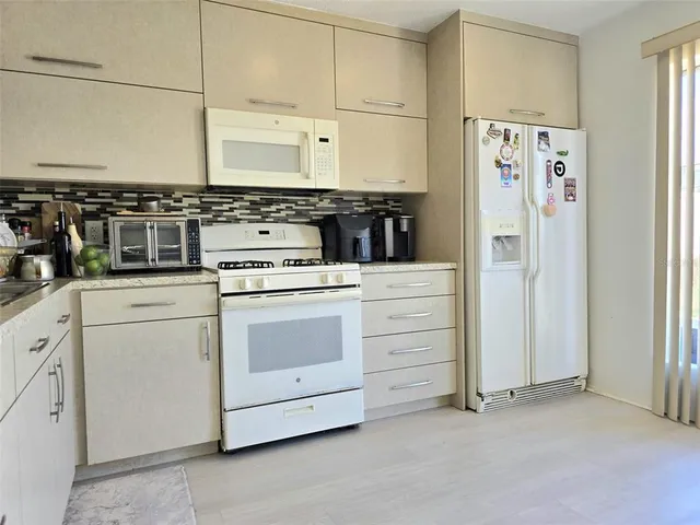 a kitchen with cabinets and white appliances
