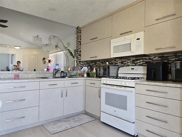 a kitchen with white cabinets and white appliances