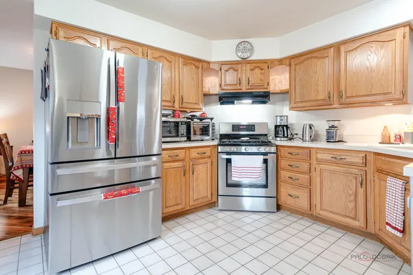 a kitchen with stainless steel appliances granite countertop a stove a sink and white cabinets