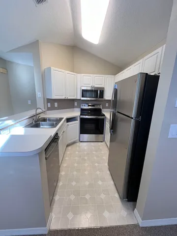 a kitchen with a sink a refrigerator a stove a microwave and cabinets