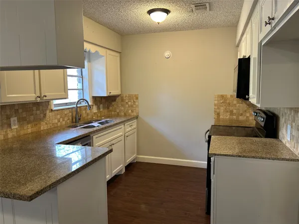 a kitchen with stainless steel appliances granite countertop a sink and a stove