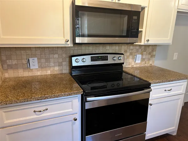 a kitchen with microwave cabinets and stove