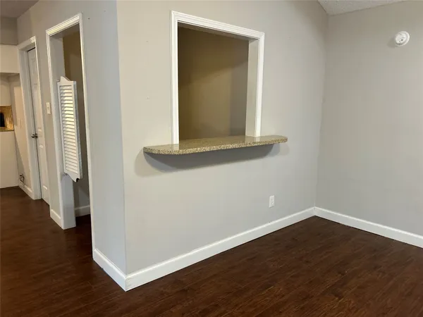 a view of a small space with wooden floor and a window