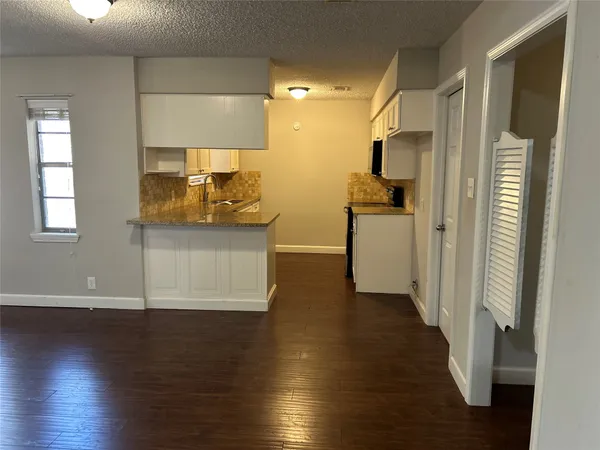 a view of a kitchen with a fridge and wooden floor