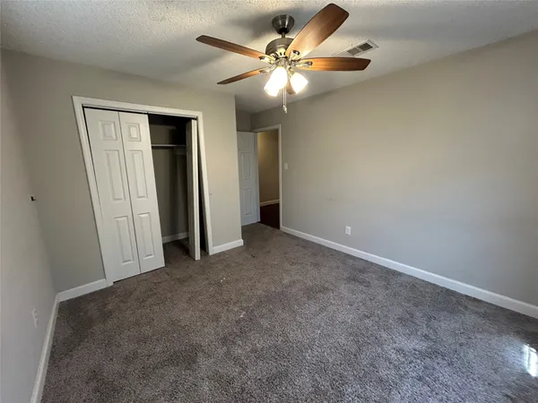 an empty room with fan and entrance