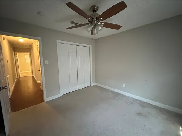 a view of an empty room and a ceiling fan