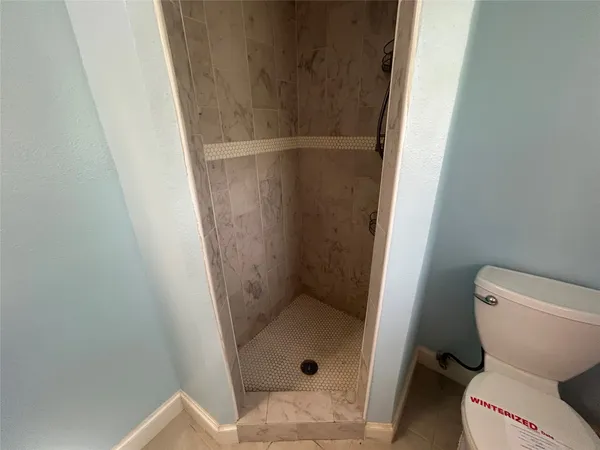 a bathroom with a toilet and a shower