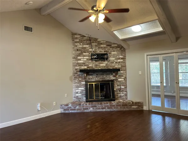 a living room with wooden floor and a fireplace