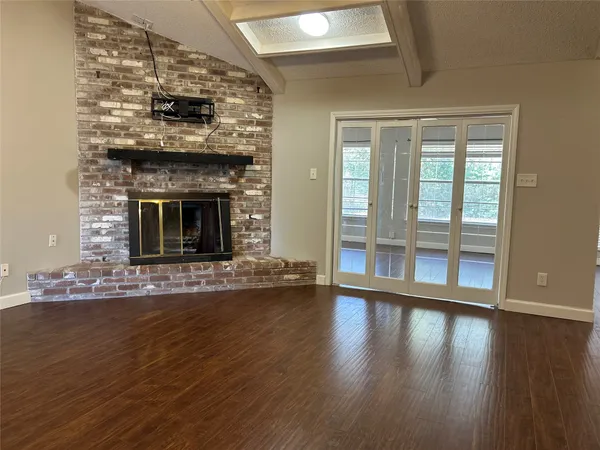 a living room with wooden floor and a fireplace