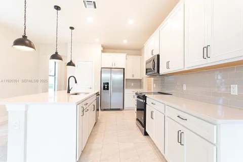 a kitchen with stainless steel appliances granite countertop a sink a stove and a refrigerator