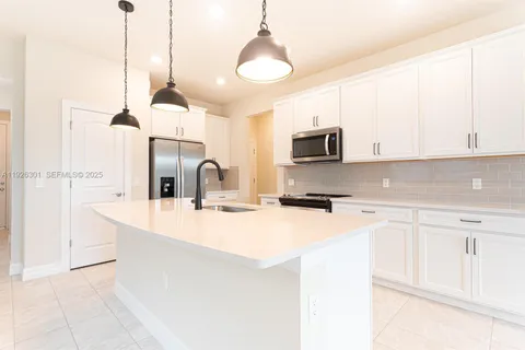 a kitchen with stainless steel appliances granite countertop a sink a stove and a refrigerator