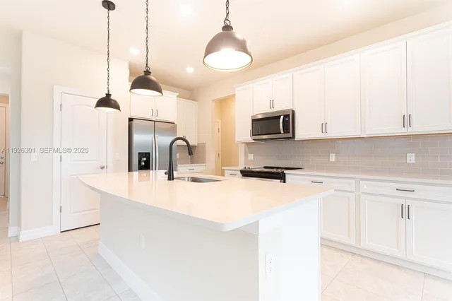 a kitchen with stainless steel appliances granite countertop a sink a stove and a refrigerator