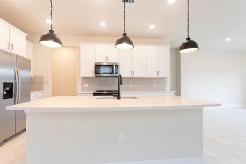 a kitchen with kitchen island a counter top space a sink and a refrigerator