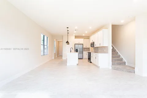 a view of kitchen with refrigerator sink and cabinets