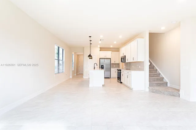 a view of kitchen with refrigerator sink and cabinets