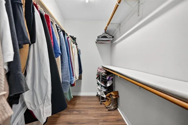 a view of walk in closet with clothes and shoes