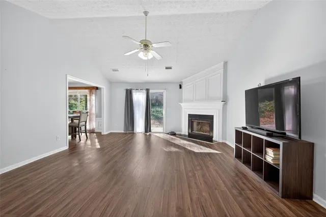a view of empty room with wooden floor fireplace and a window