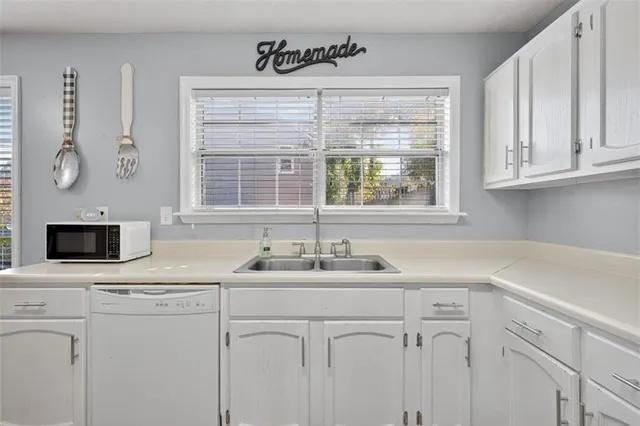 a kitchen with stainless steel appliances white cabinets and a sink
