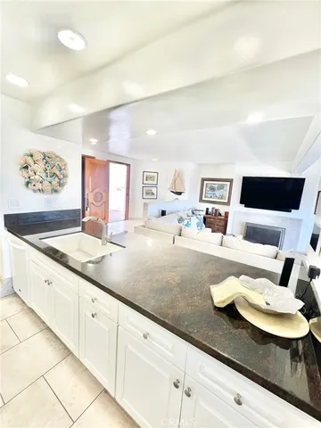 a living room with granite countertop white cabinets and white appliances