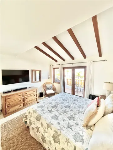 a large bedroom with a large bed and a flat tv screen