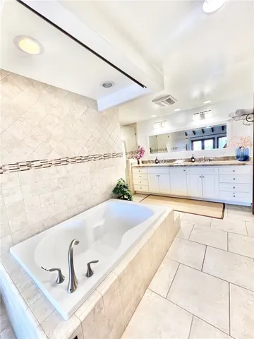 a large white kitchen with stainless steel appliances kitchen island granite countertop a sink and cabinets
