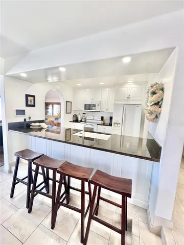 a kitchen with stainless steel appliances granite countertop table chairs sink and cabinets