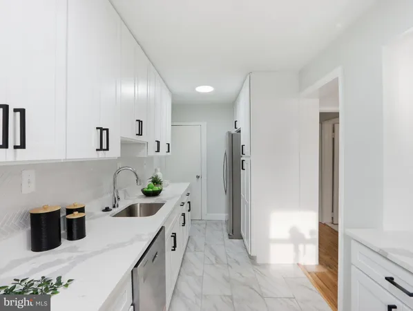 a kitchen with stainless steel appliances a sink a refrigerator and a cabinets