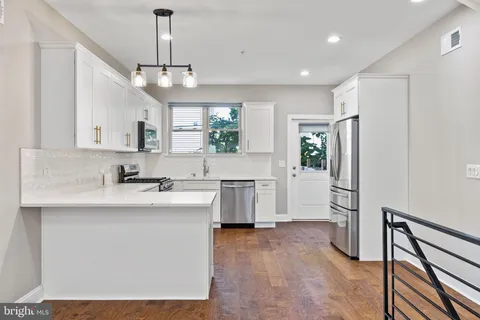 a kitchen with white cabinets appliances and sink