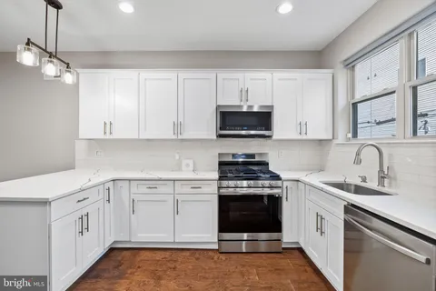 a kitchen with a refrigerator sink and cabinets