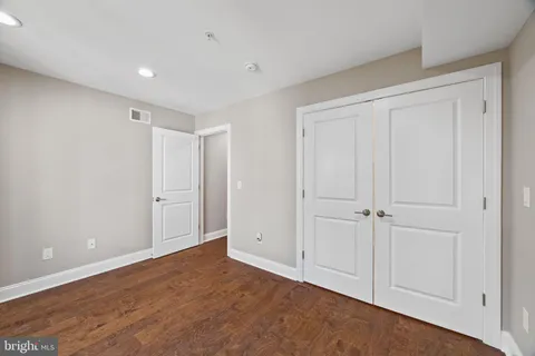 a bathroom with a granite countertop toilet sink and mirror