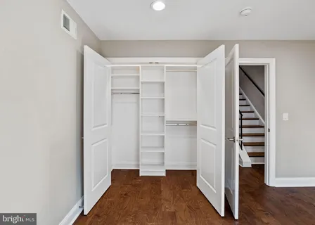 a view of a hallway with wooden floor and entryway